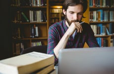 A young man researches in the library.