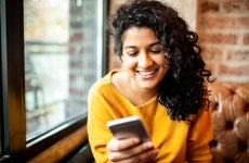 Woman using mobile phone at the bar